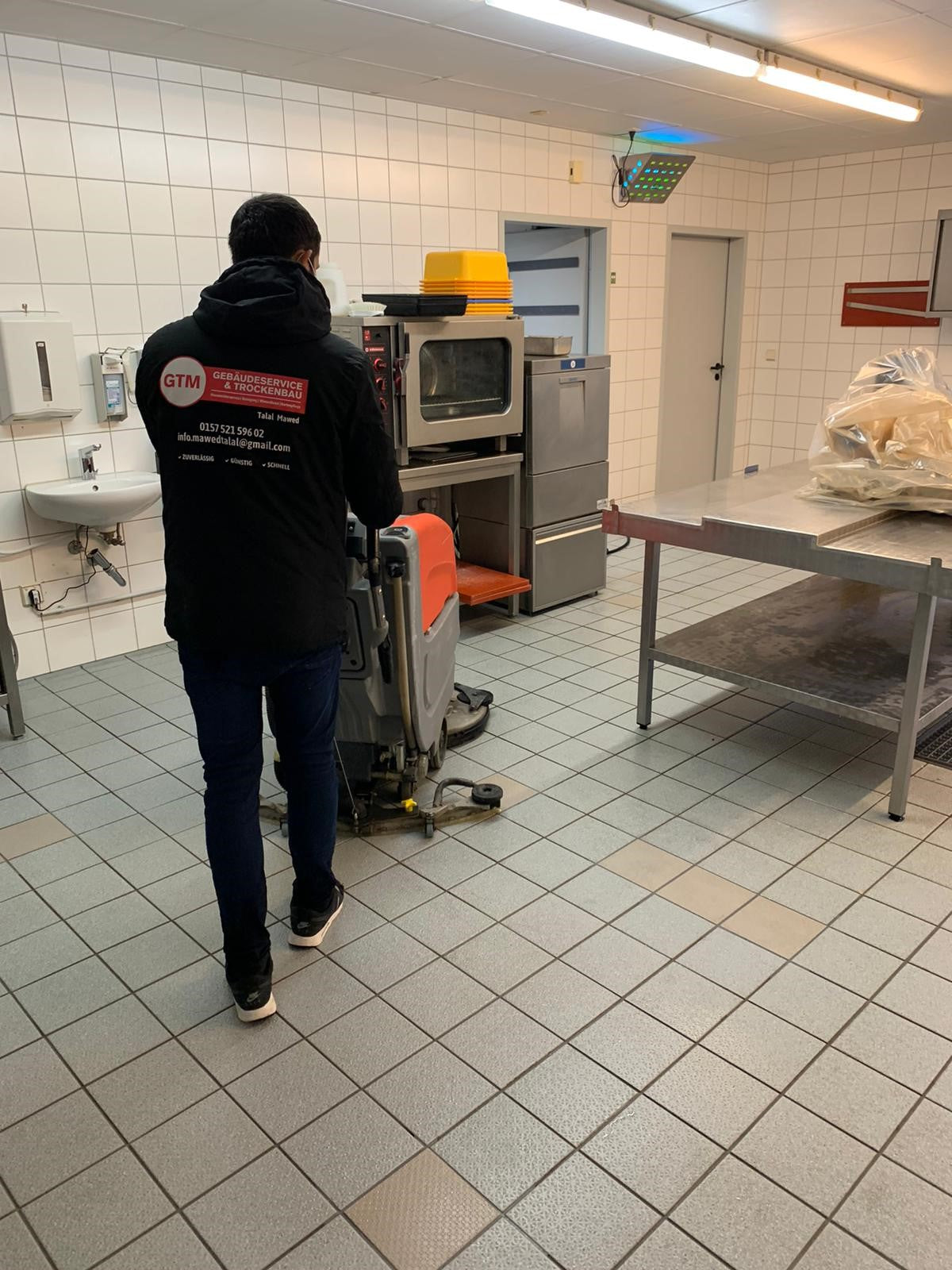 GTM Mitarbeiter bei der maschinellen Bodenreinigung in einem Gewerbebetrieb